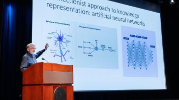 Keith Holyoak presenting slide 2 showcasing a neuron versus an artificial neuron