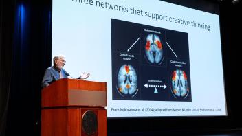 Keith Holyoak presenting slide 5 showcasing brain imaging scans