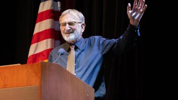 Keith Holyoak standing at podium concluding presentation