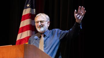 Keith Holyoak standing at podium concluding presentation